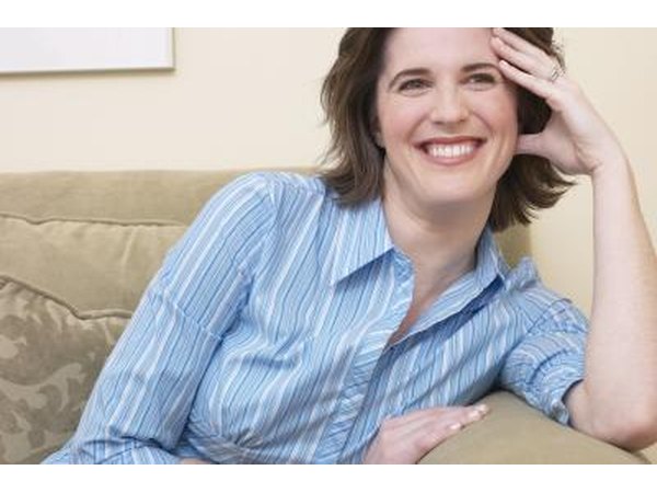 Slightly embarrassed woman looking and smiling on the couch.