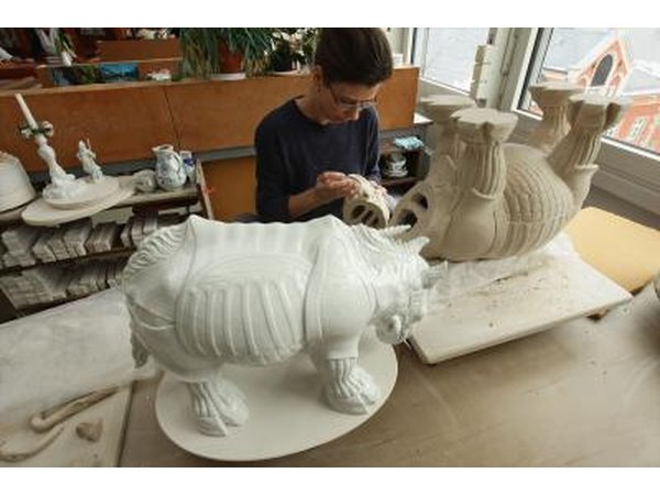 An artist makes a porcelain statue of a rhinoceros.