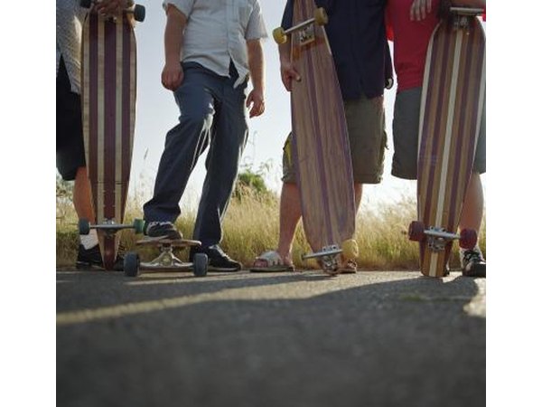 A group of skaters standing with longboards.