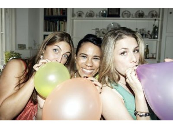 girls blowing up balloons with air