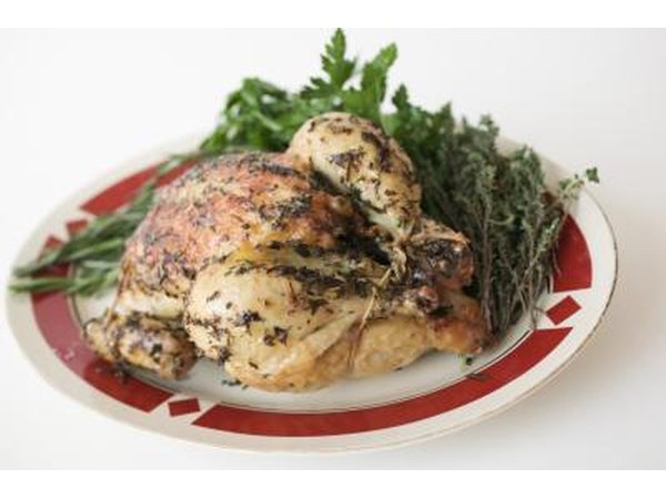 A roasted chicken with vegetables on a plate.