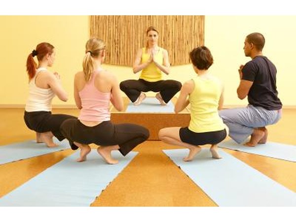 A yoga class does prayer squat.