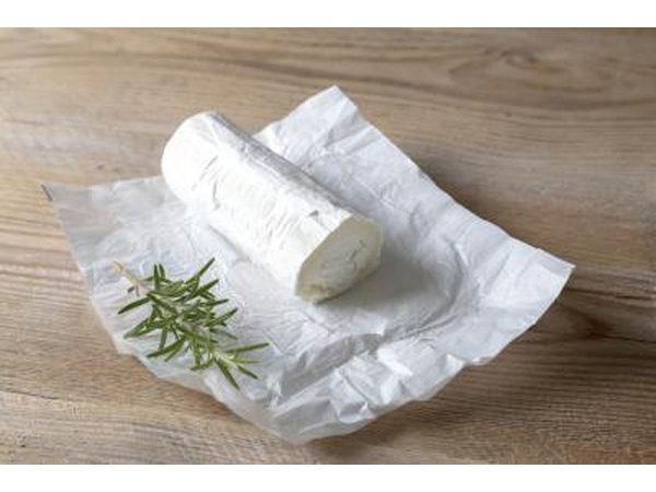 Fresh log of goat cheese on paper