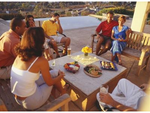 A group of friends relaxing on wooden patio furniture.
