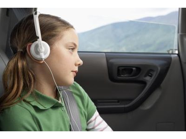 Young girl wearing headphones in a car.