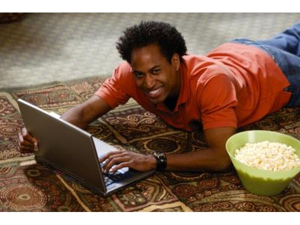 man watching movie on his computer