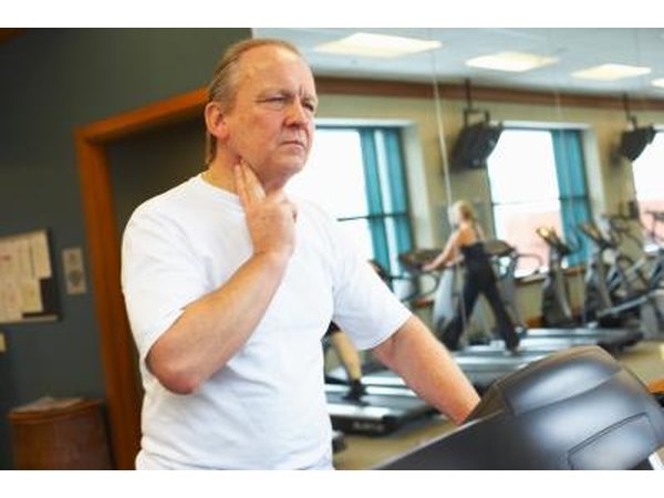 man checking heart rate on elliptical machine