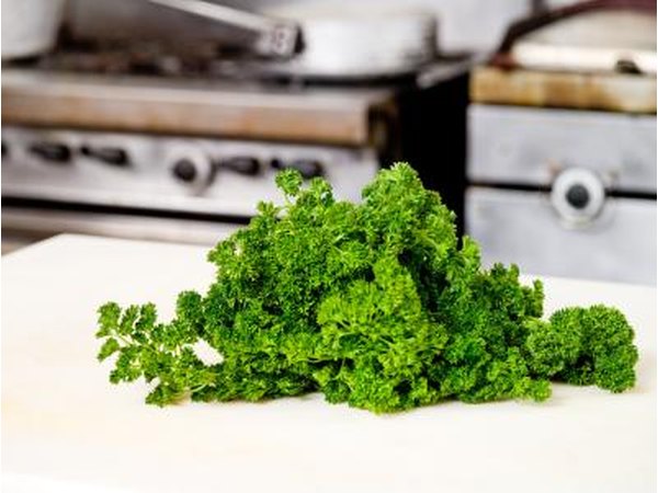 A bunch of fresh parsley on a cutting board.