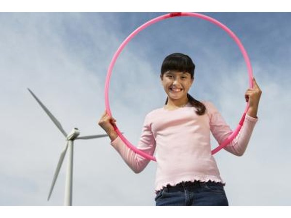 young girl holding hula hoop in field
