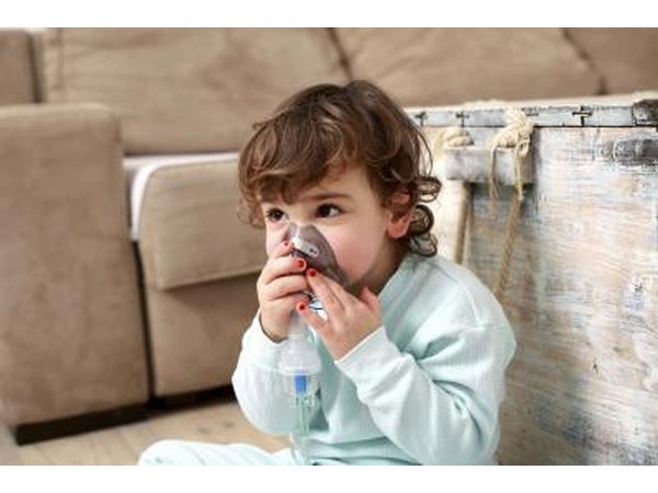 A small child uses an inhaler mask.