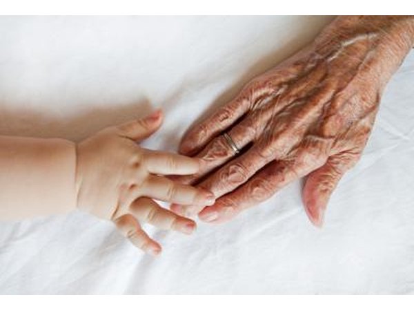 Baby touching Great Grandmothers hand