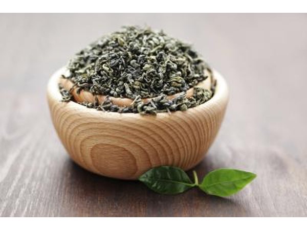 Bowl of green tea leaves on a table