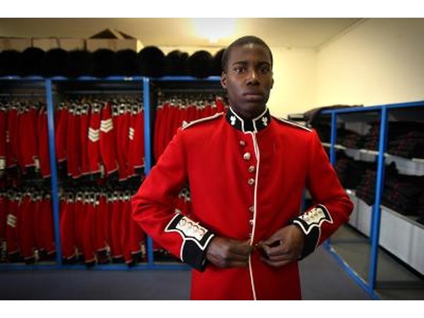 An Irish soldier puts on a red jacket for a St. Patrick's Day parade.