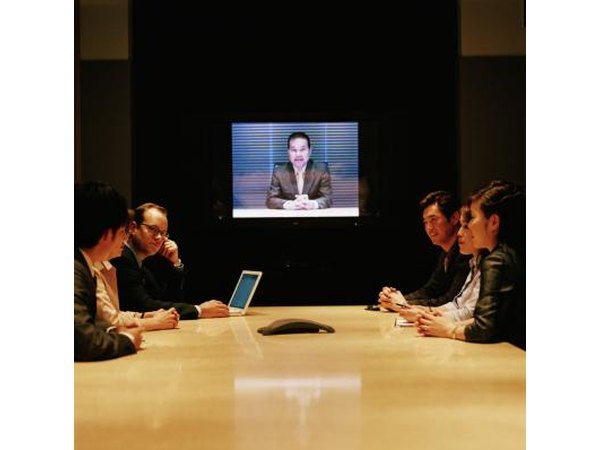 Employees meet in the conference room for a webinar.