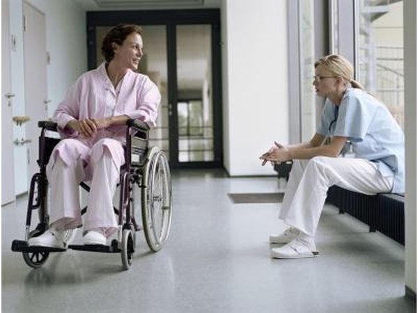 Nurse talking with patient in wheelchair.