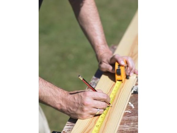 Construction worker measuring with measuring tape