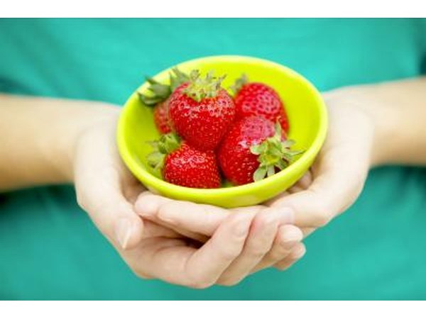 Girl holding bowl of strawberries
