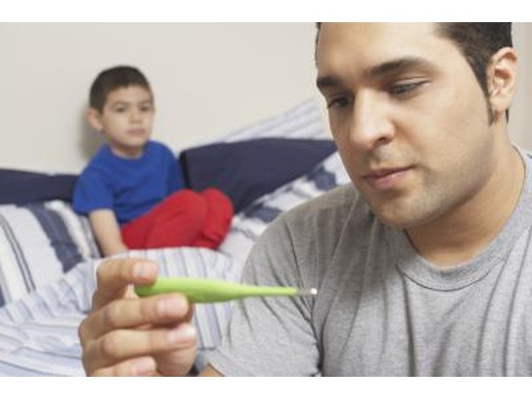 A father takes his son's temperature.