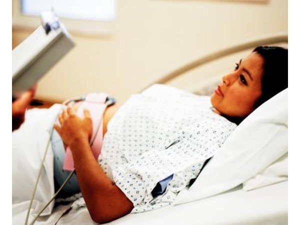 Woman having abdomen checked by doctor