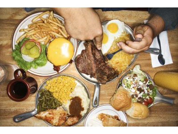 Man eating from multiple plates of food
