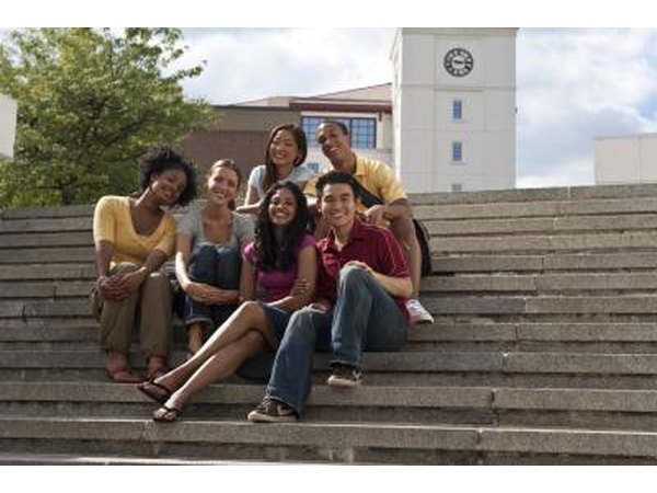 Young students happily sitting outside school.