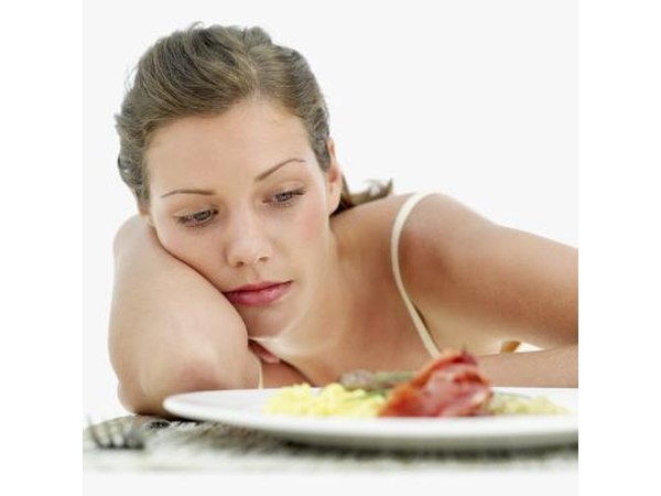 Feeling sick, a woman passes on a plate of food.
