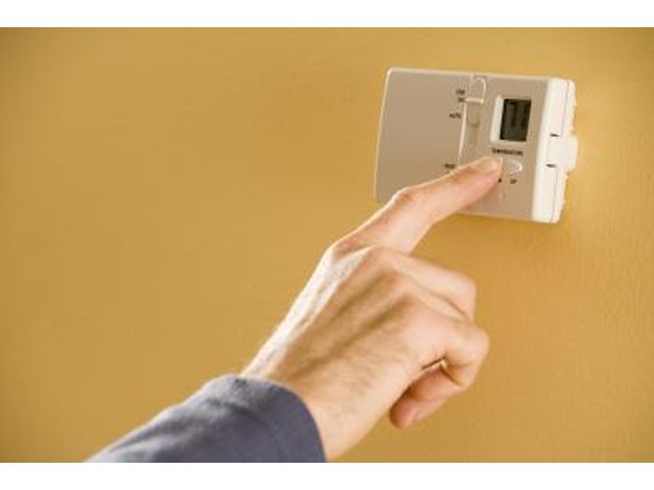 Man adjusting thermostat