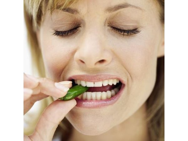 Woman biting into green chili