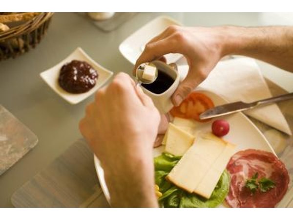 A man adds a cane sugar cube to a cup of espresso.