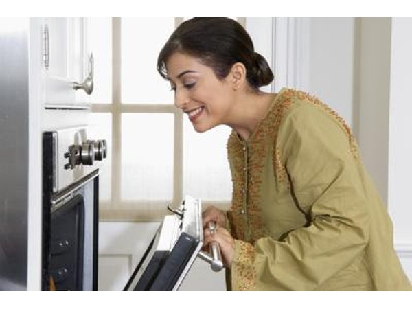 Woman opening conventional oven.