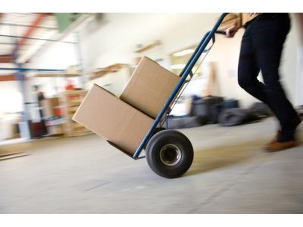 Pushing handtruck with boxes on it.
