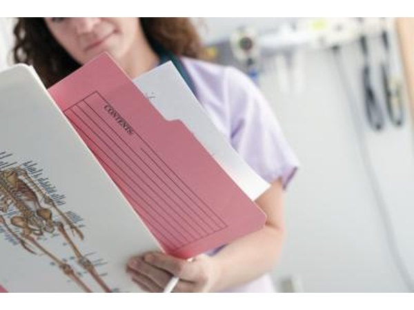 Nurse holding patients chart Nurse looking at chart