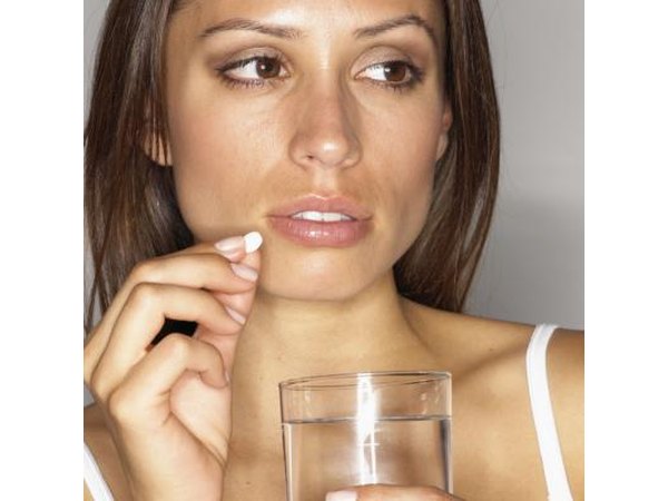 woman taking pill with water