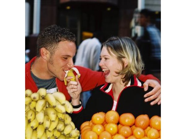Banana being fed to man at food market stall