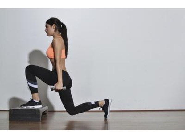 A woman doing weighted lunges.