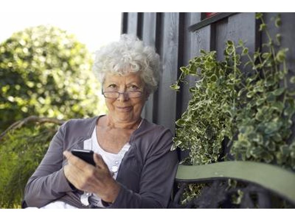 A woman uses her smart phone in the backyard.