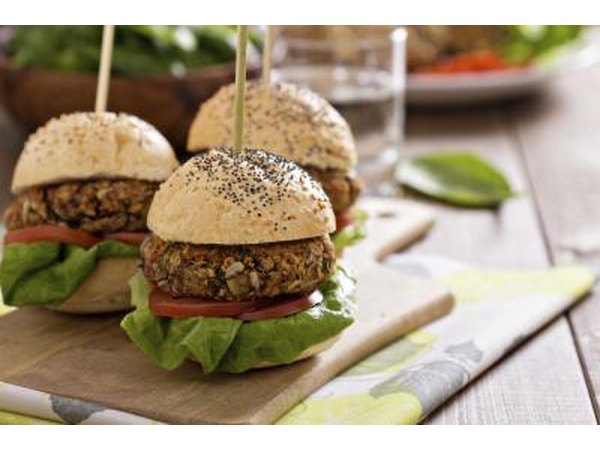 Vegetarian burgers on a bun with lettuce and tomato.