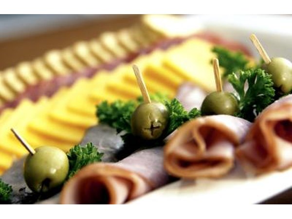 A platter of finger foods including olives and assorted meats and cheeses is a great idea for large parties