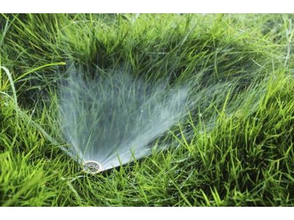 Close-up of sprinkler in grass field