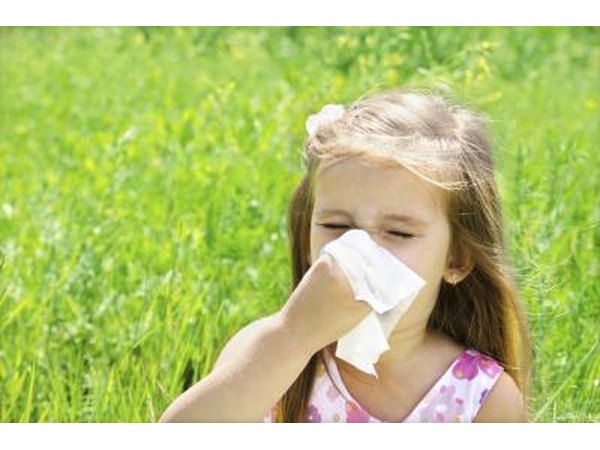 A girl blows her nose outside.