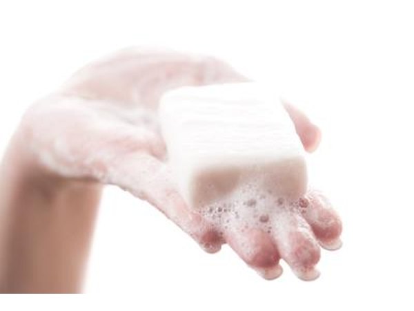 Woman with soapy hand and bar of soap.
