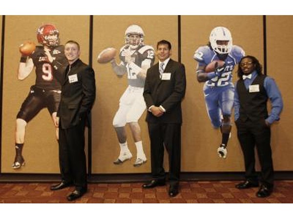 College Football Players next to life-size posters of themselves