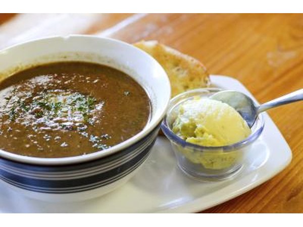 A bowl of traditional creole gumbo served at a restaurant table.