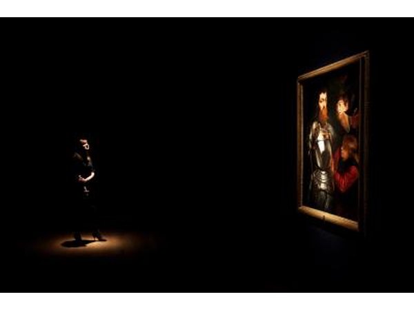 A woman examines a painting by Peter Paul Rubens.
