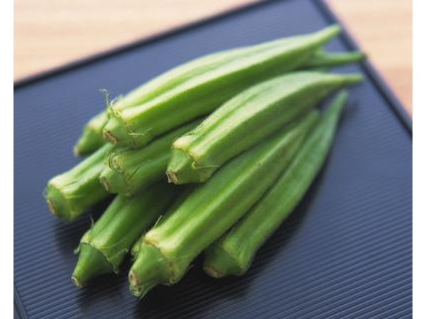 Several okras on a black plate.
