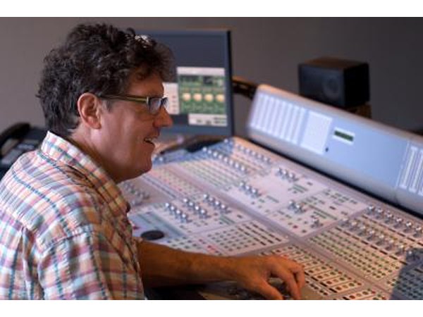 A sound engineer sits at the sound board.