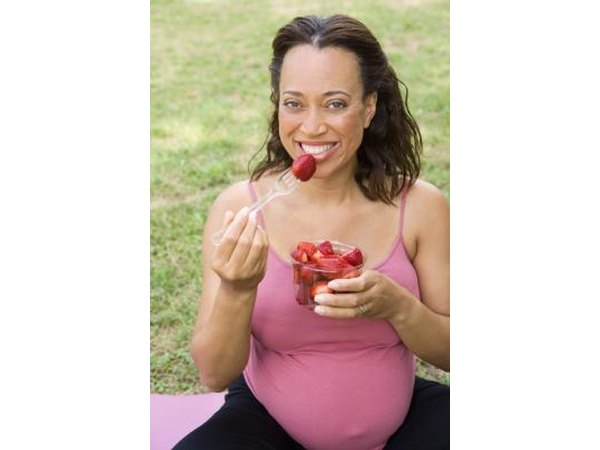 Pregnant woman eating strawberries