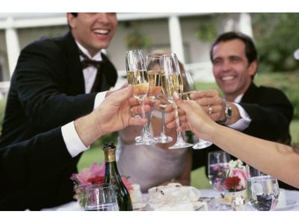 The bride and groom make a toast at the table with members of the wedding party.