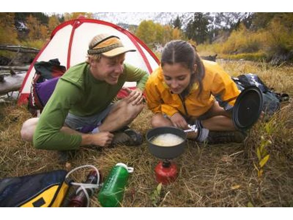 Couple cook near camping tent