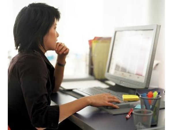 A woman analyzes data on a laptop.